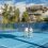 <p style="text-align: justify;">La intervención, ejecutada en seis semanas, ha incluido la rehabilitación completa del pavimento, la aplicación de un nuevo revestimiento deportivo profesional y la sustitución del cerramiento perimetral.</p>
 
<p style="text-align: justify;">El Ayuntamiento ha culminado la renovación integral de dos pistas de tenis del complejo Elena Benítez, una actuación que ha permitido recuperar por completo las superficies de juego, reforzar la seguridad y mejorar las prestaciones de ambas canchas.</p>
<p style="text-align: justify;">El teniente de alcalde sampedreño, Javier García, y el concejal del ramo, Lisandro Vieytes, han visitado los trabajos ejecutados en el equipamientos. García ha indicado que esta intervención “se enmarca en la mejora continua que estamos llevando a cabo en las infraestructuras deportivas de San Pedro Alcántara para que nuestros vecinos dispongan de espacios públicos modernos y en las condiciones más óptimas”.&nbsp; El edil ha subrayado que “es un centro de referencia, con una importante actividad durante todo el año, por lo que es fundamental seguir adaptándolo a las necesidades de sus usuarios”.</p>
<p style="text-align: justify;">El teniente de alcalde ha explicado que los trabajos, con un plazo de ejecución de seis semanas, “han permitido transformar completamente dos superficies que presentaban un importante desgaste por el uso y el paso del tiempo”.</p>
<p style="text-align: justify;">Vieytes, por su parte, ha resaltado que “las pistas cuentan ahora con una superficie deportiva certificada para una velocidad media de juego y la señalización reglamentaria se ha realizado conforme a los criterios de la Real Federación Española de Tenis, mediante pinturas microtexturadas antideslizantes”, al tiempo que ha resaltado que “el resultado son dos canchas plenamente acondicionadas, con unas prestaciones adecuadas para practicar este deporte con mayores garantías de calidad”.</p>
<p style="text-align: justify;">El edil ha detallado que “el pavimento de hormigón registraba grietas superficiales y había perdido parte de sus propiedades de agarre y elasticidad, una situación que afectaba tanto a la regularidad del bote de la pelota como a la seguridad de los deportistas, por lo que no se ha realizado un simple repintado, sino una rehabilitación técnica completa de las canchas, desde la preparación de la base hasta la aplicación de un nuevo sistema profesional de revestimiento”.</p>
<p style="text-align: justify;">En una primera fase, se retiraron las juntas deterioradas y se sellaron con adhesivos elásticos de alta resistencia, al tiempo que se efectuó un pulido mecánico con diamante para nivelar la superficie. Asimismo, las grietas fueron abiertas, aspiradas y tratadas mediante resinas epoxídicas, mientras que los desniveles se corrigieron con morteros de nivelación rápida. El saneado de la base concluyó con una limpieza técnica a alta presión antes de proceder a la aplicación del nuevo pavimento.&nbsp;</p>
<p style="text-align: justify;">La actuación también ha incluido la instalación de un sistema semielástico de resinas acrílicas avanzadas, compuesto por una capa de imprimación, dos de regularización y otras tres de acabado y sellado texturizado, sobre la superficie. “Con este tratamiento conseguimos una pisada más confortable, una mayor absorción de impactos y, sobre todo, un comportamiento mucho más homogéneo de la pelota”, ha indicado el edil.</p>
<p style="text-align: justify;">La intervención se ha completado con la sustitución íntegra del antiguo cerramiento perimetral, que presentaba zonas deterioradas y oxidadas. El nuevo vallado incrementa la seguridad de las instalaciones e incorpora un portón que permitirá el acceso de medios auxiliares para facilitar futuras labores de conservación y mantenimiento. Vieytes ha incidido en que esta iniciativa “forma parte de la apuesta municipal por mantener y modernizar de manera permanente la red de equipamientos deportivos públicos”, y ha añadido que “es tan importante crear nuevas infraestructuras como conservar las existentes y garantizar que los vecinos puedan utilizarlas en las mejores condiciones posibles”.</p>